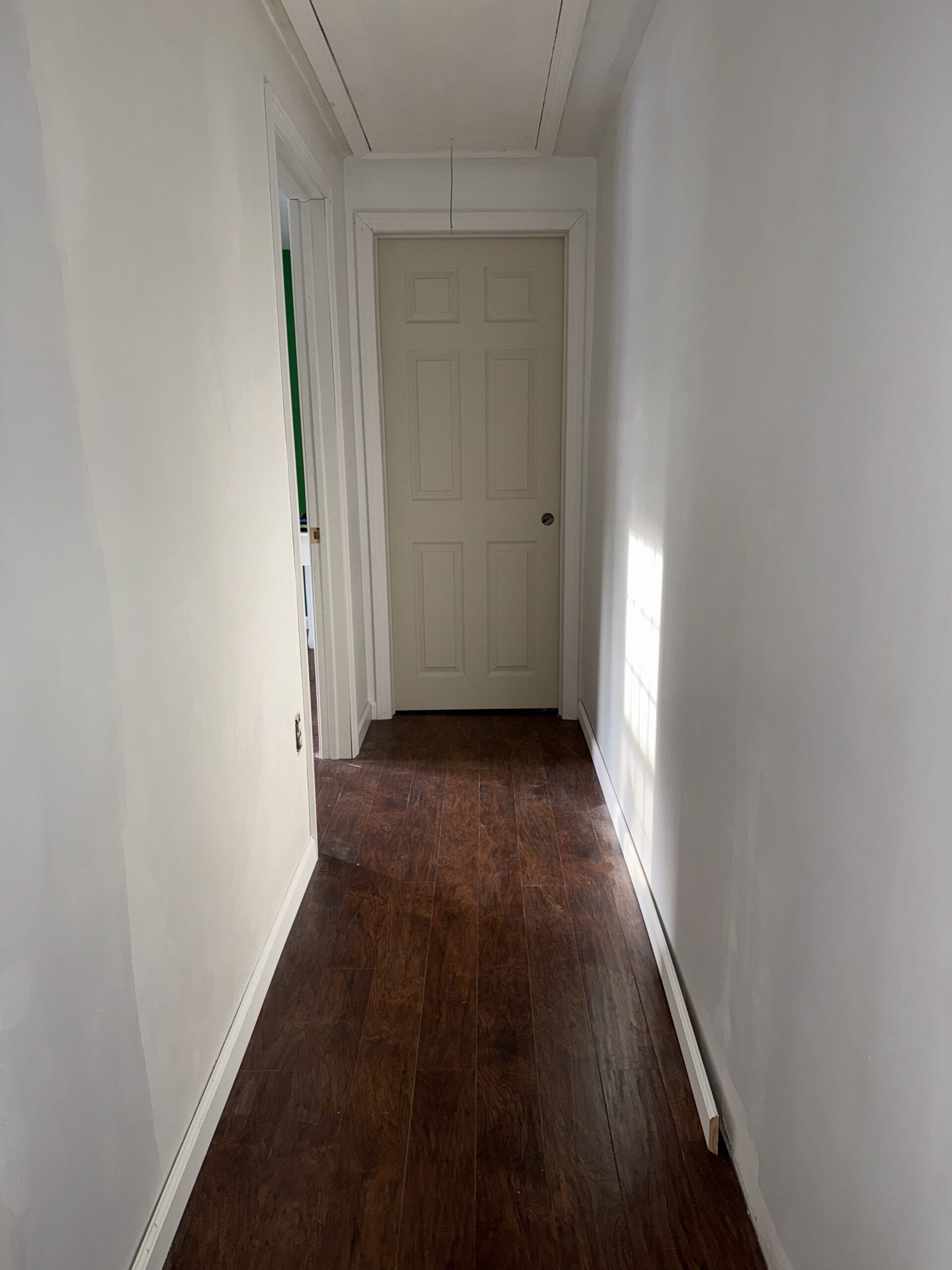 Completed upstairs hallway with new flooring walls trim and door in Bridgewater Massachusetts