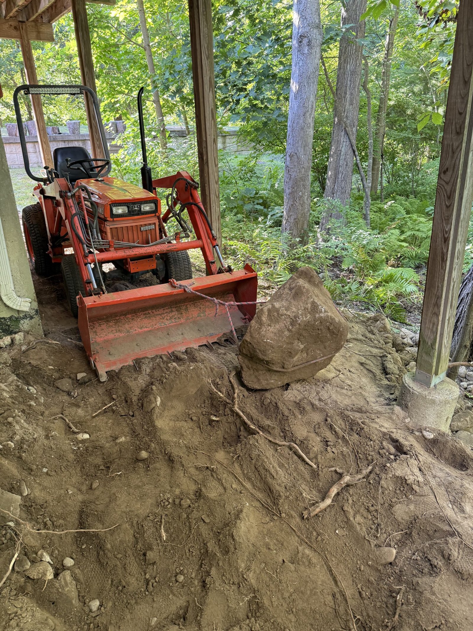 Excavator removing heavy rock from the future patio area in Dover Massachusetts