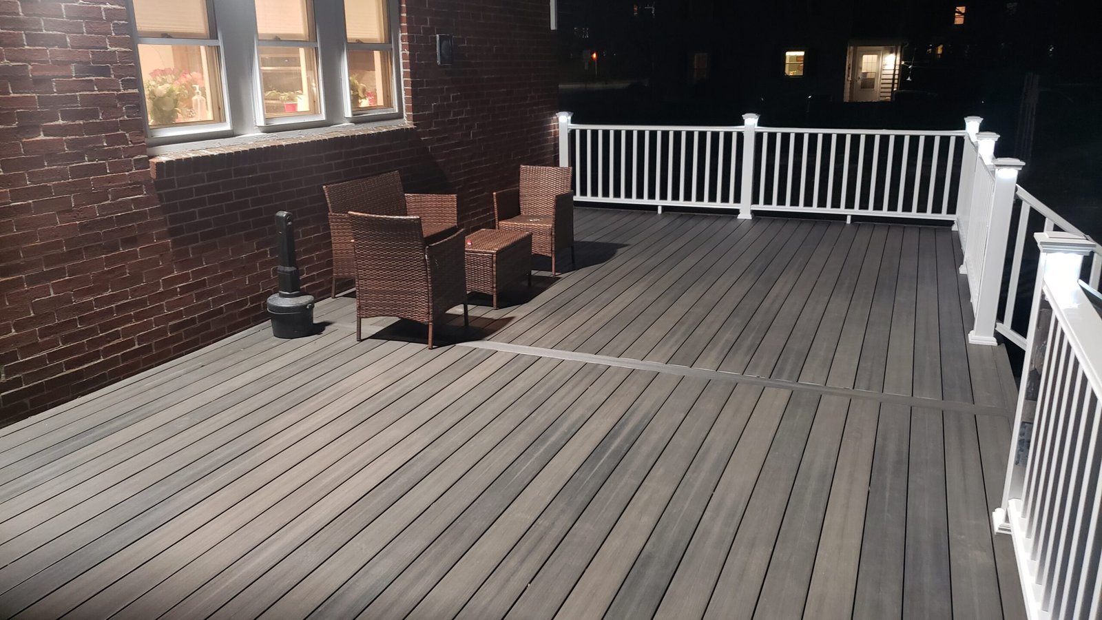 Finished Marblehead deck with outdoor seating white railings and broad center stairs