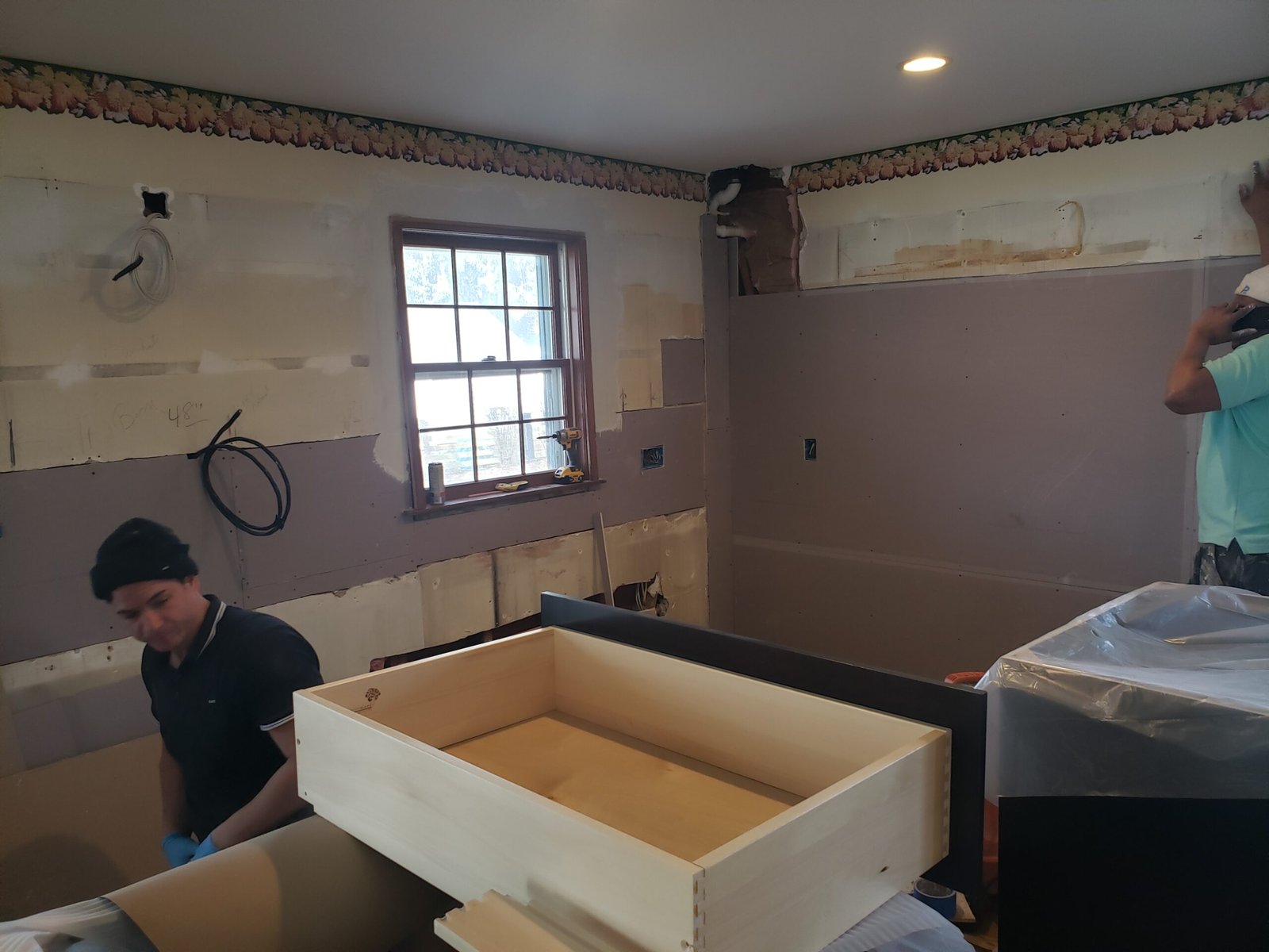 Base cabinet boxes being assembled and positioned in a Marblehead kitchen