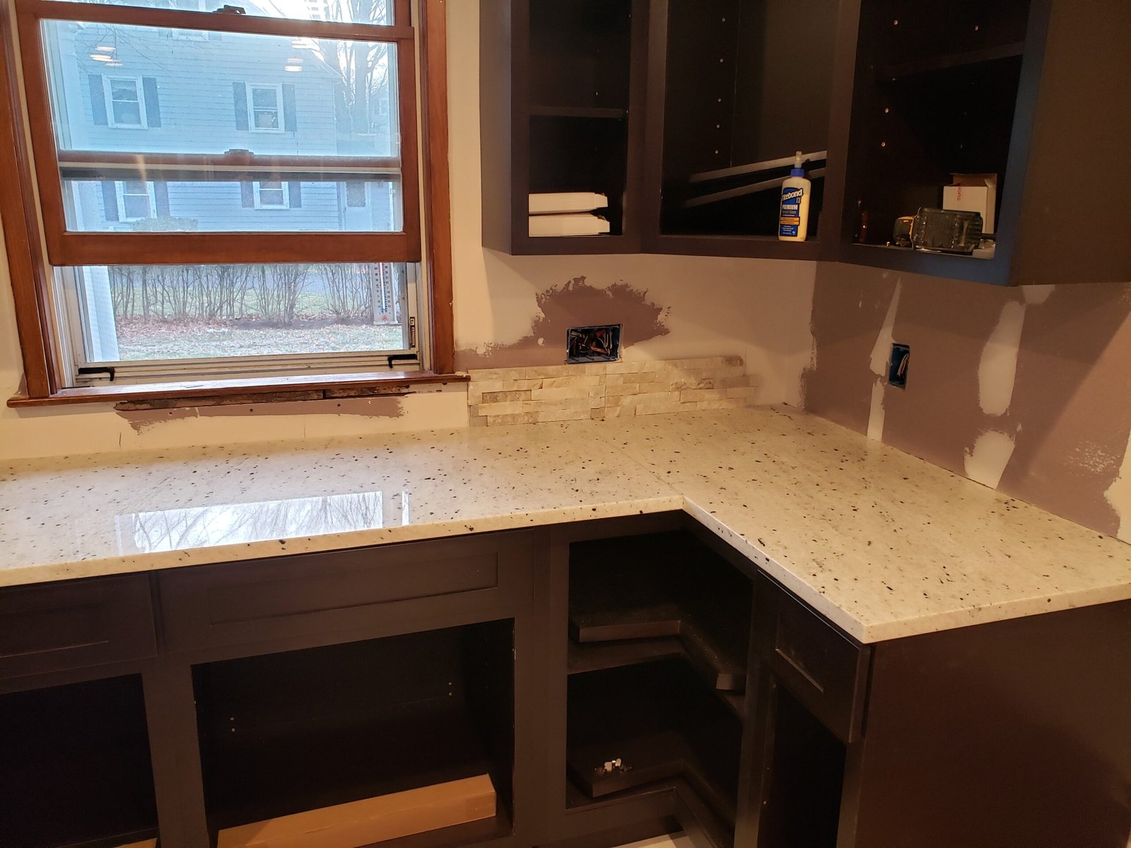 New countertops and dark cabinetry during finish work in a Marblehead kitchen remodel