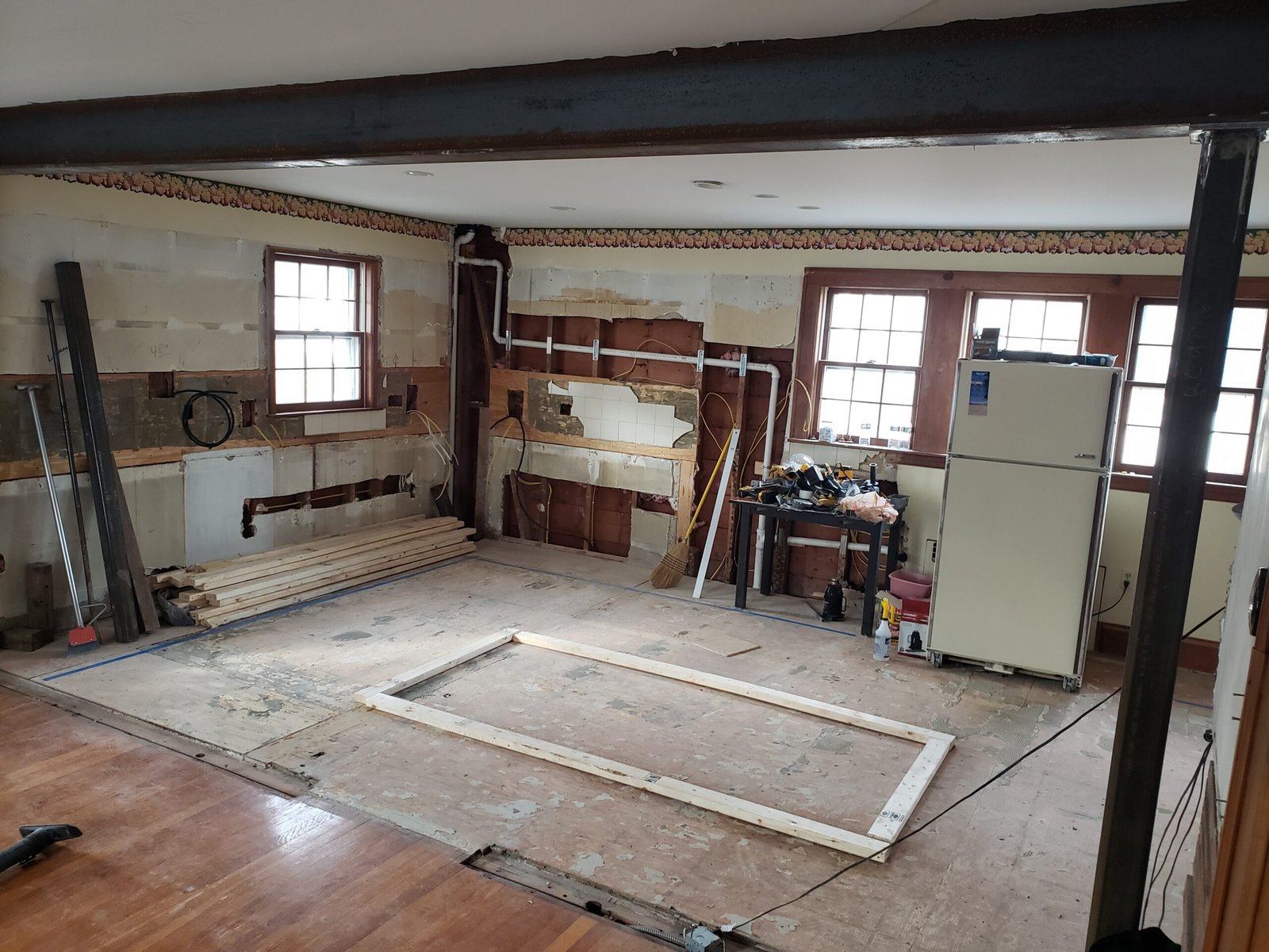 Wide view of the opened kitchen and dining room after wall removal in Marblehead Massachusetts