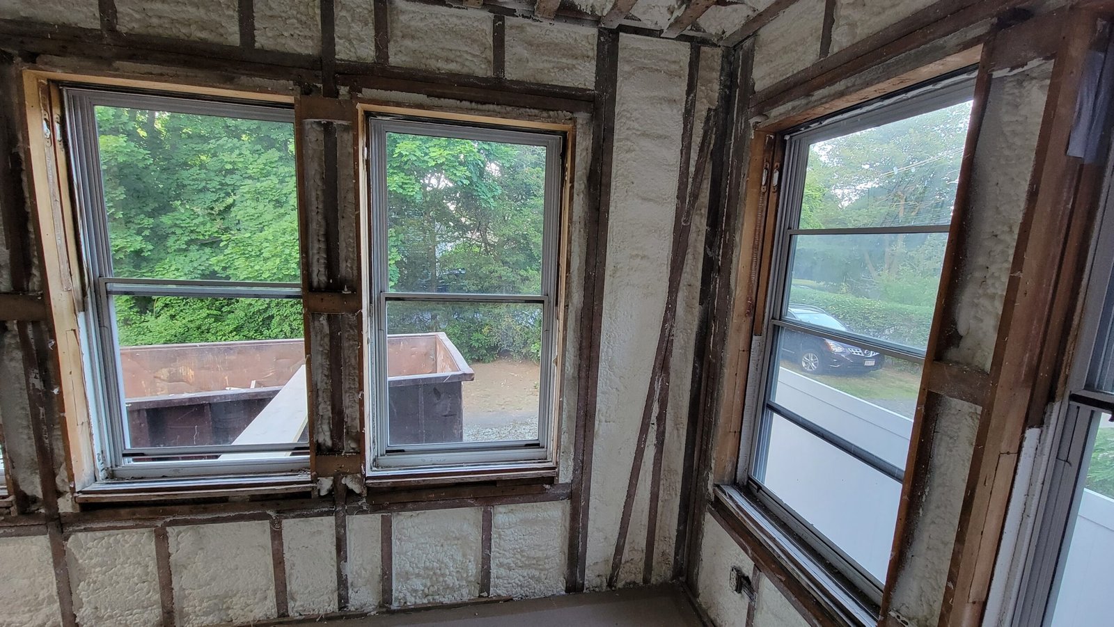 Multiple window openings and exposed wall framing during a Marblehead office rebuild