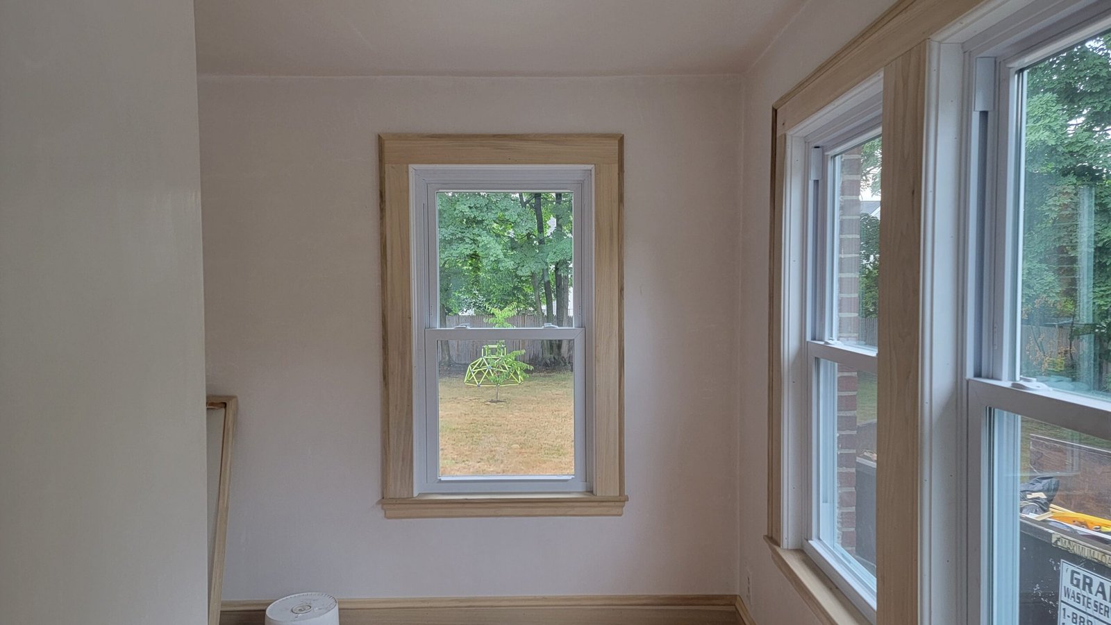 Finished Marblehead office with white walls natural wood window trim and restored hardwood flooring