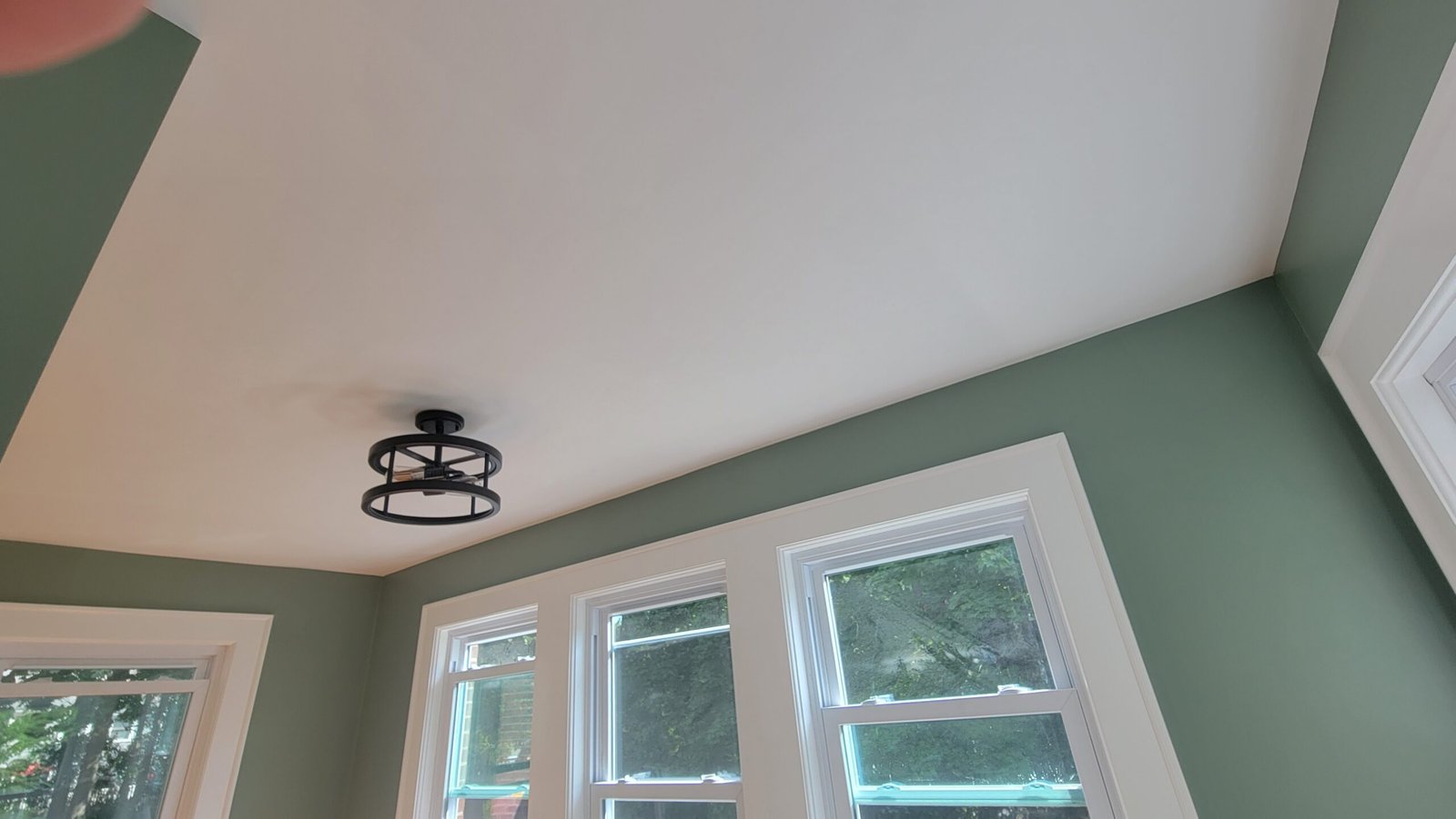 Finished green accent walls white ceiling window trim and ceiling light in a Marblehead office