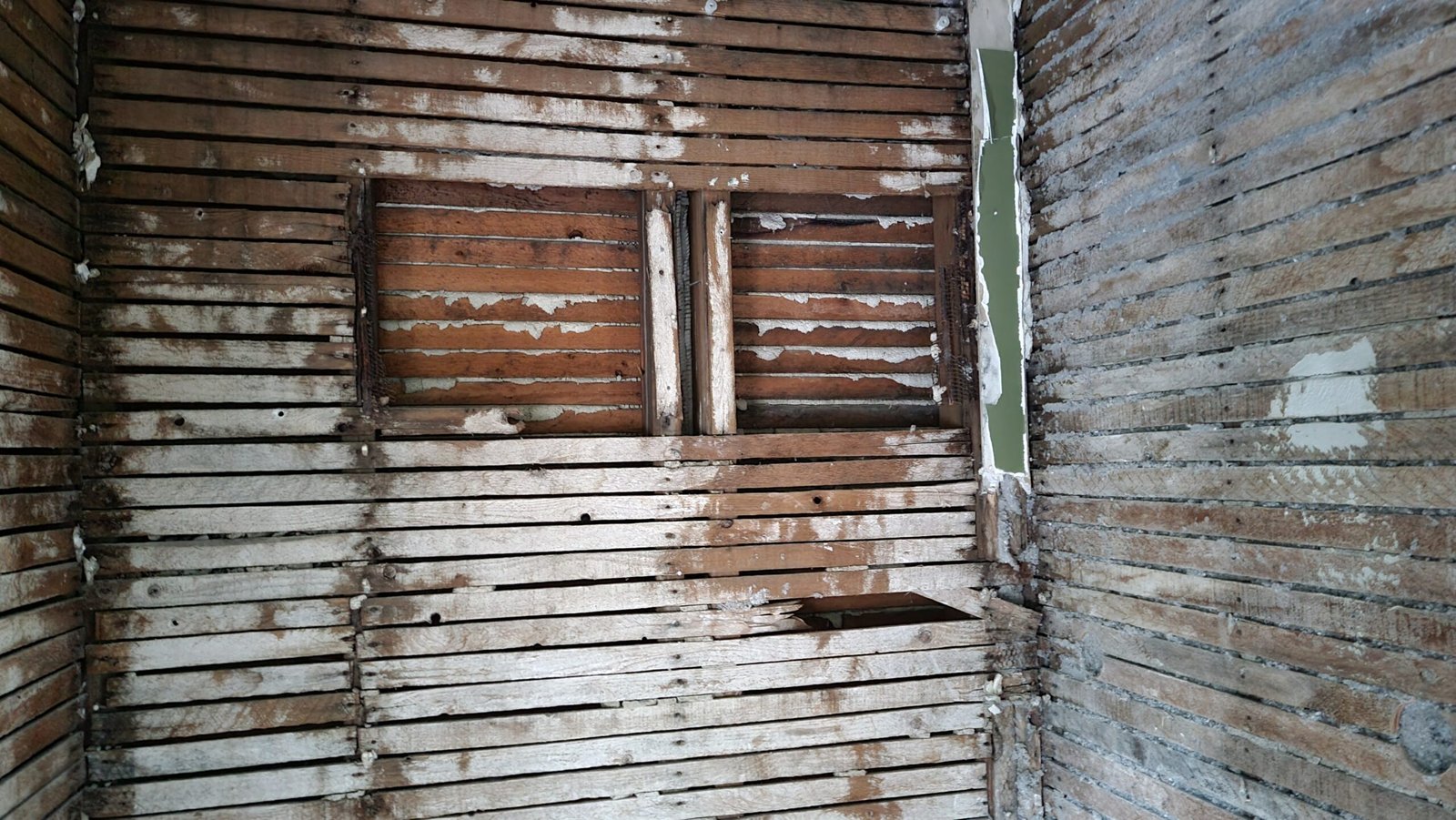 Close view of exposed wood lath and wall structure during a Marblehead office renovation