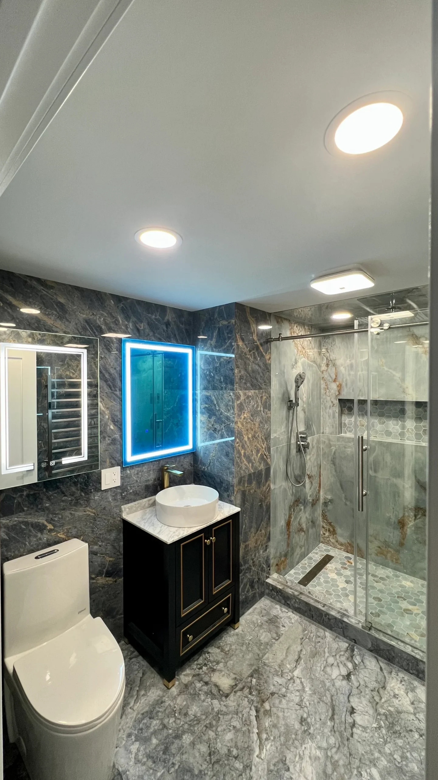 Completed bathroom with illuminated mirror glass shower and marble-pattern tile in Salem Massachusetts