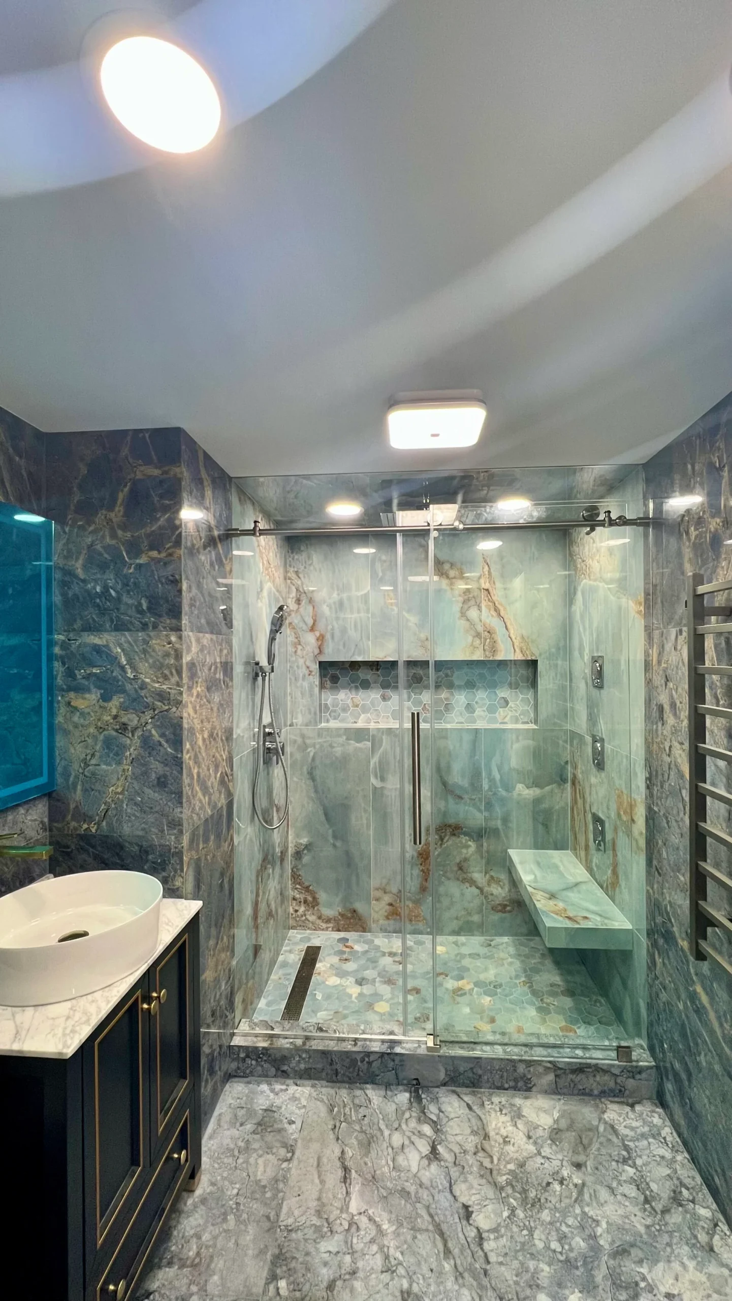 Finished walk-in shower and vanity with blue accent tile in a Salem home renovation