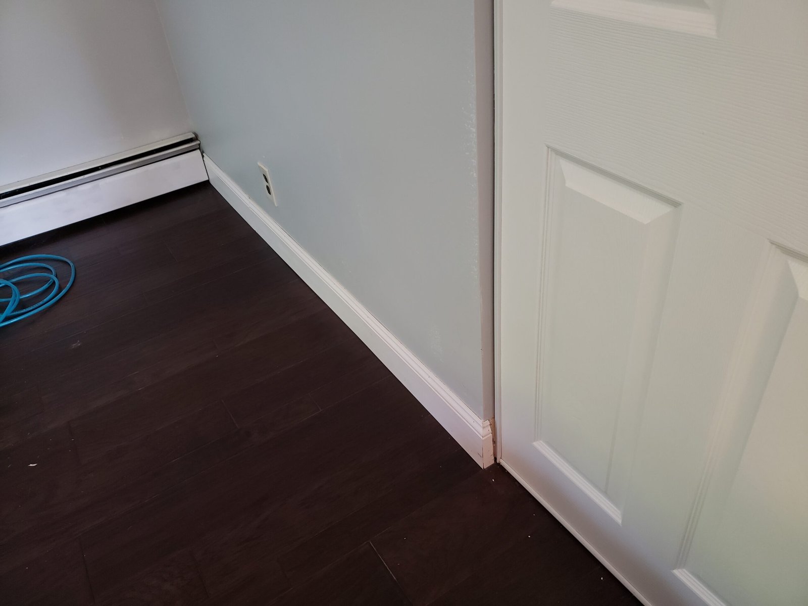 Engineered hardwood flooring white baseboard and finished doorway detail in a Saugus home renovation