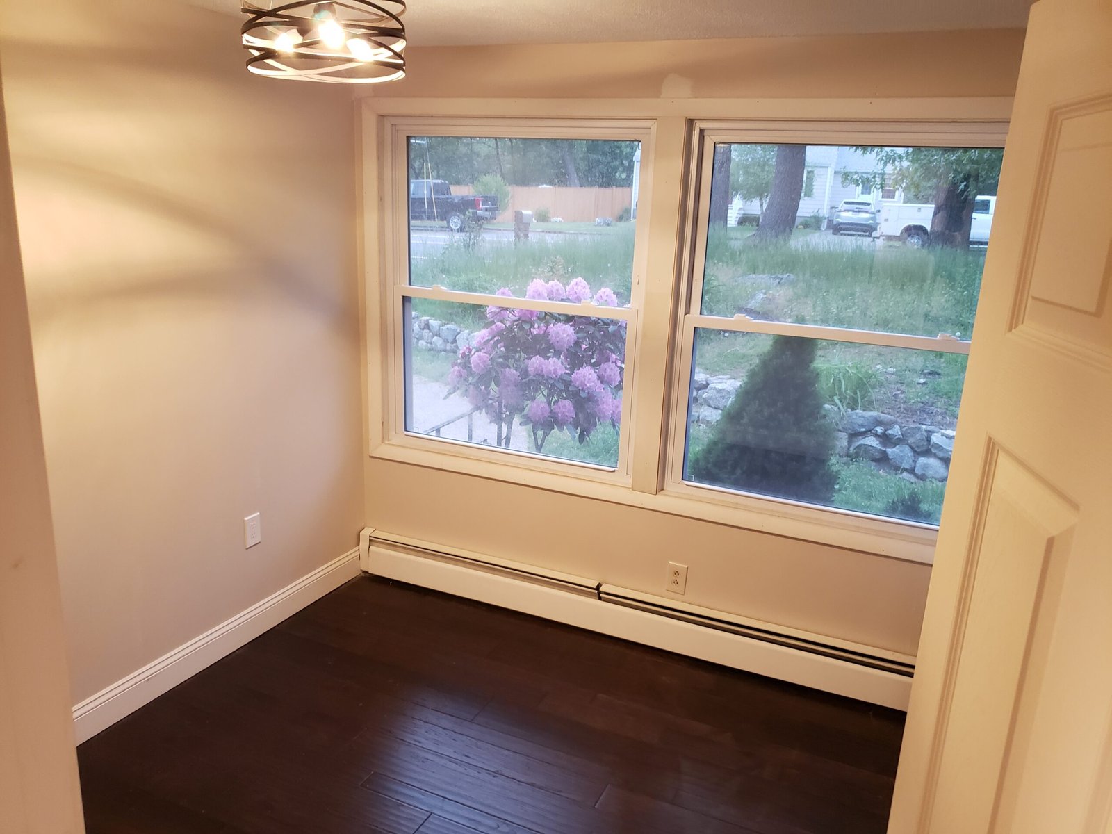 Finished Saugus bedroom with new window hardwood flooring walls and ceiling fan
