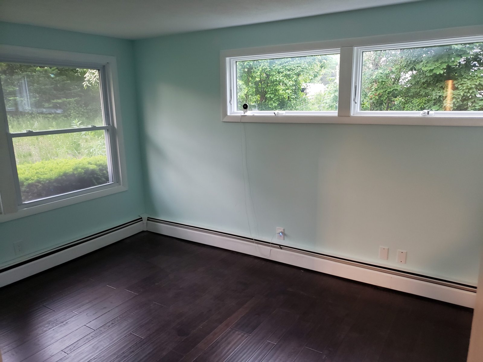 Completed room with larger windows and dark engineered hardwood flooring in Saugus Massachusetts