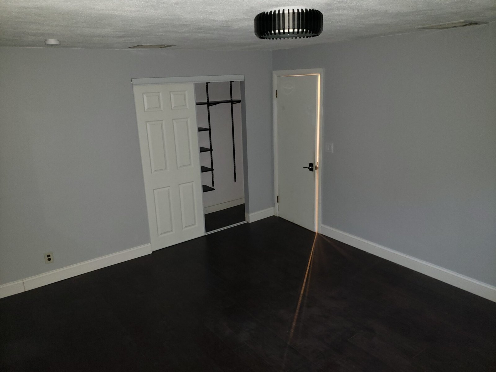 Completed Saugus room with French doors white trim and dark engineered hardwood floor