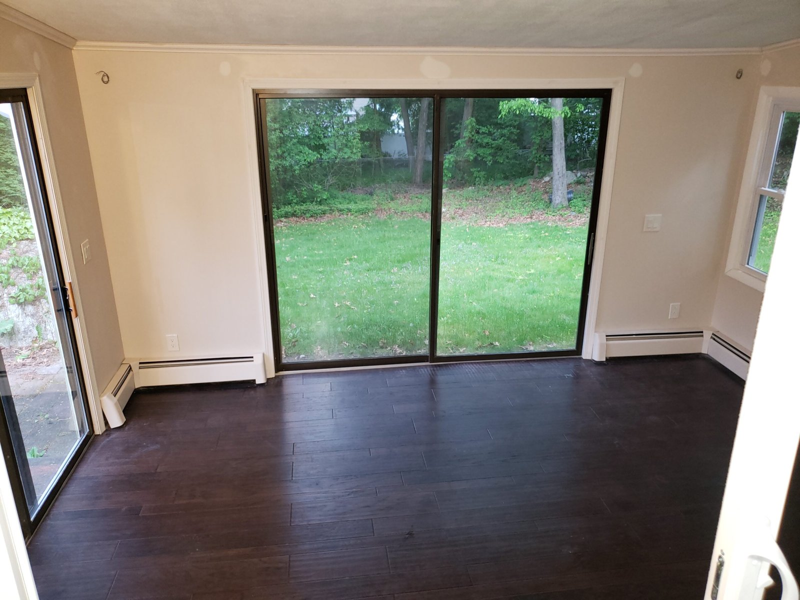 Finished sunroom with sliding glass doors and engineered hardwood flooring in Saugus Massachusetts