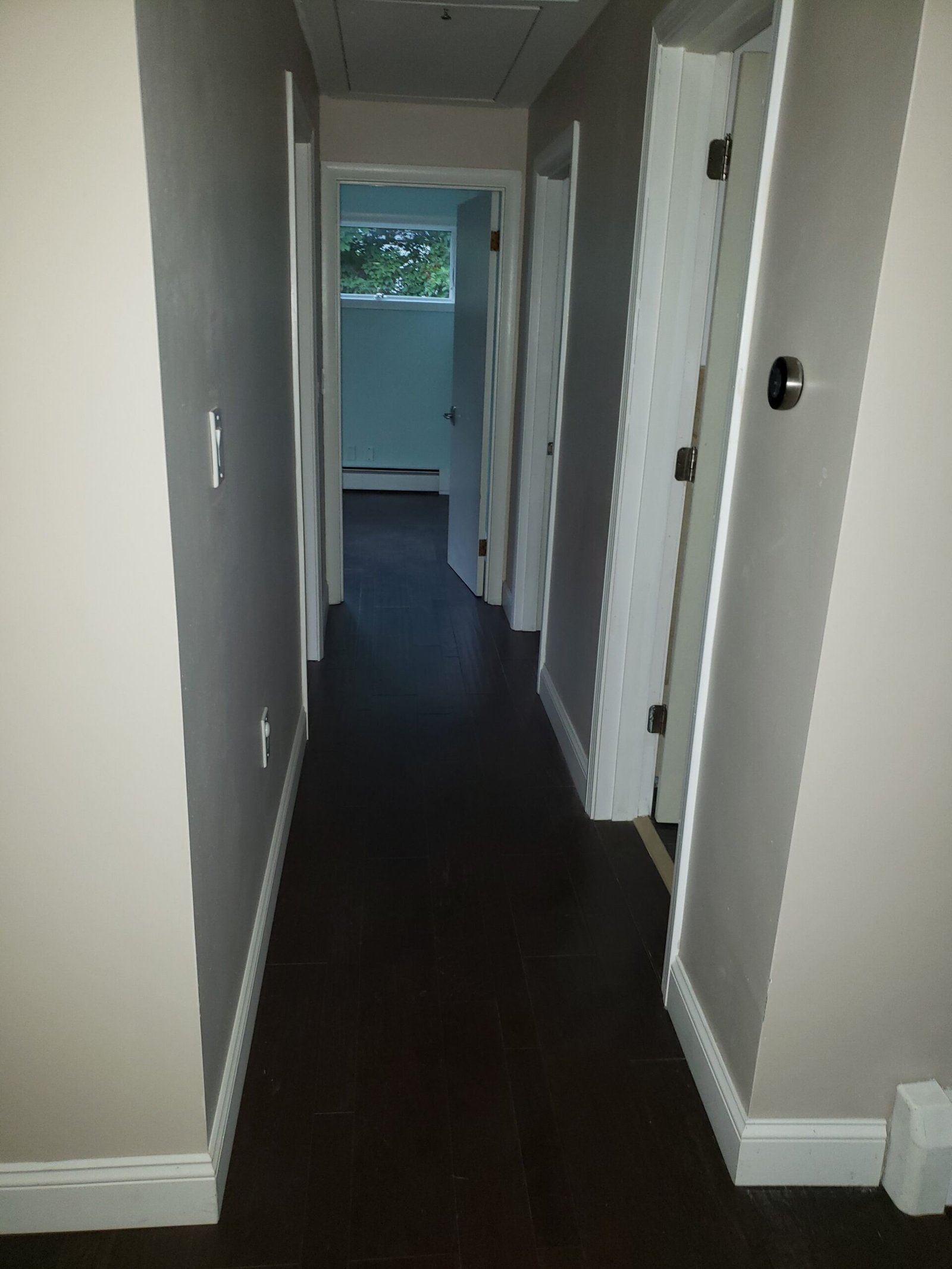 Completed interior hallway with white walls trim and engineered hardwood flooring in Saugus