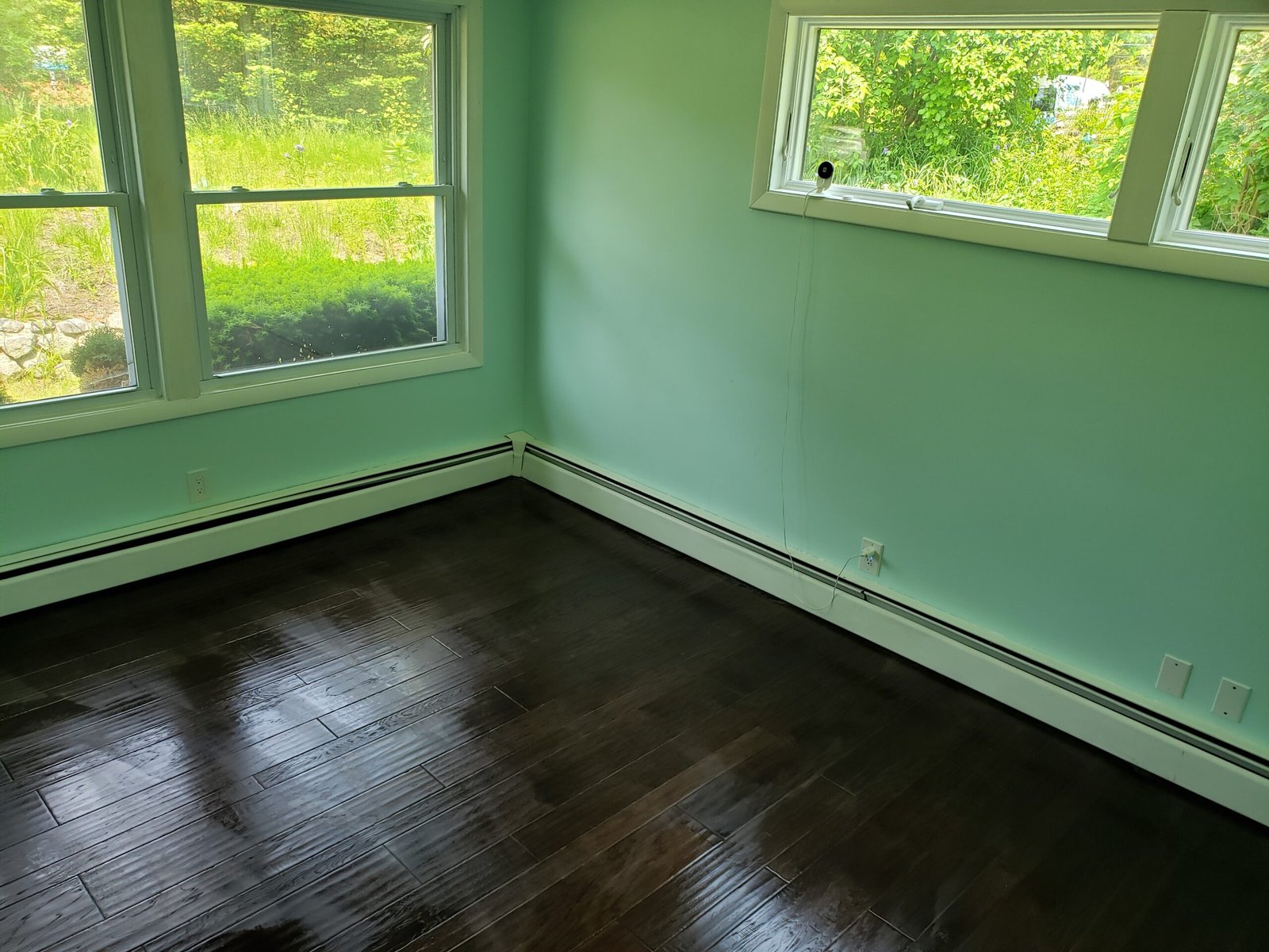 Finished corner room with multiple larger windows and engineered hardwood flooring in Saugus