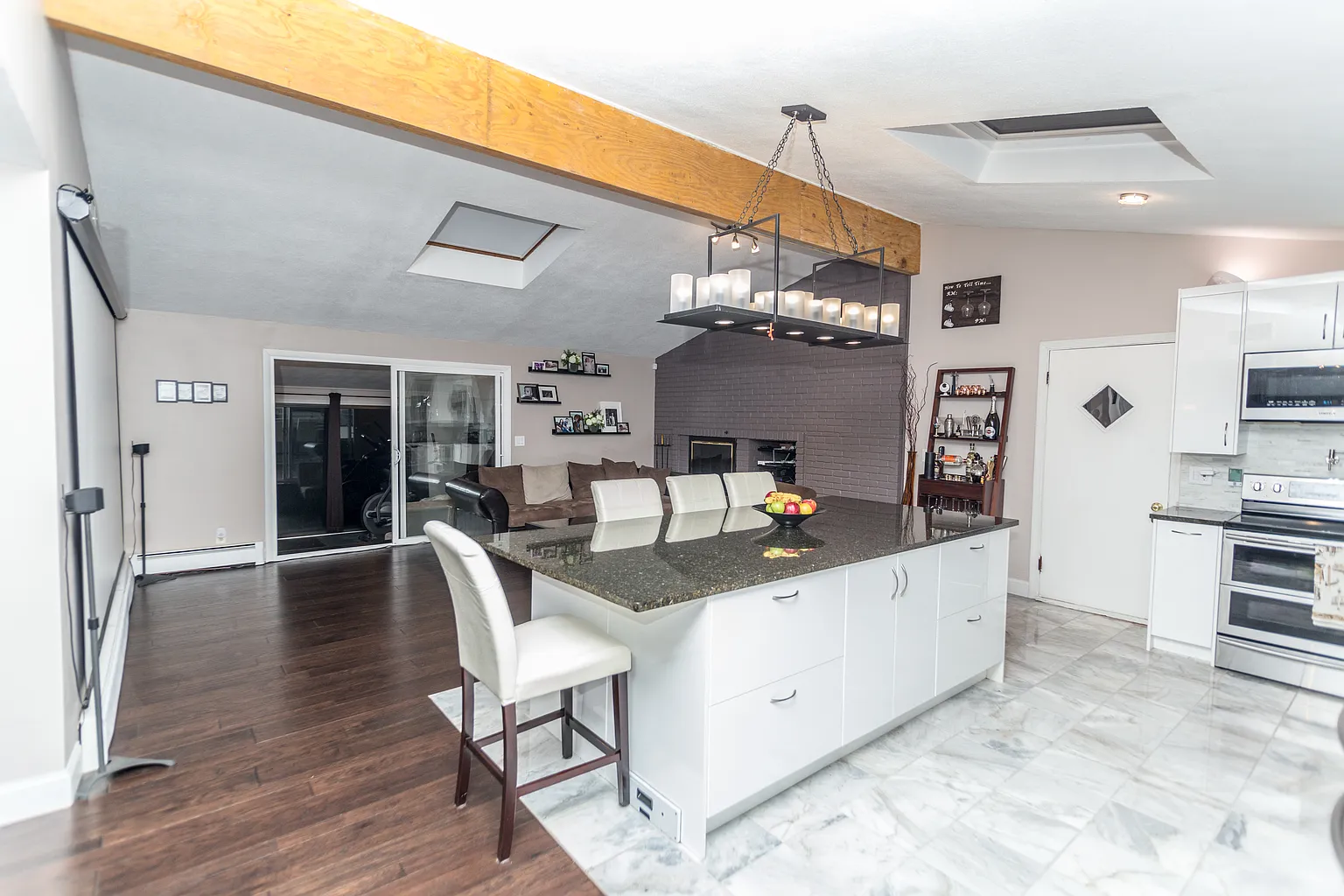 Wide final view of the Saugus kitchen island LVL beam skylights and living area