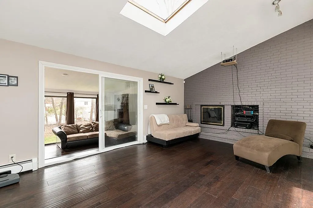 Professionally staged living room with fireplace and skylight after a Saugus whole-house renovation