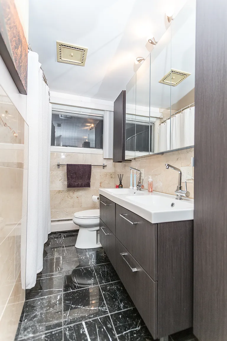 Professionally staged bathroom vanity dark floor and tiled tub area in Saugus Massachusetts