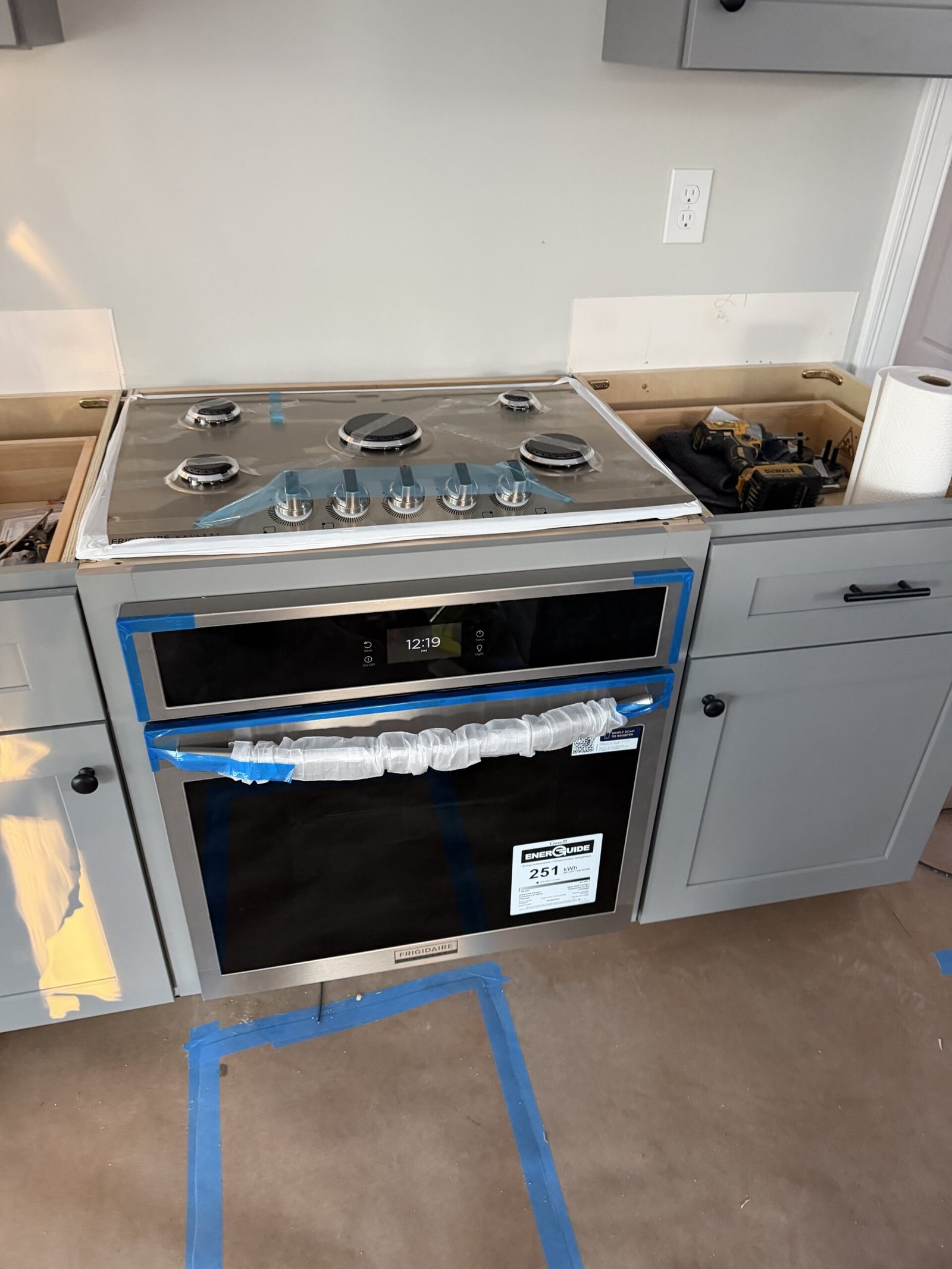 Built-in wall oven and cooktop installed in a custom gray kitchen cabinet in Uxbridge Massachusetts