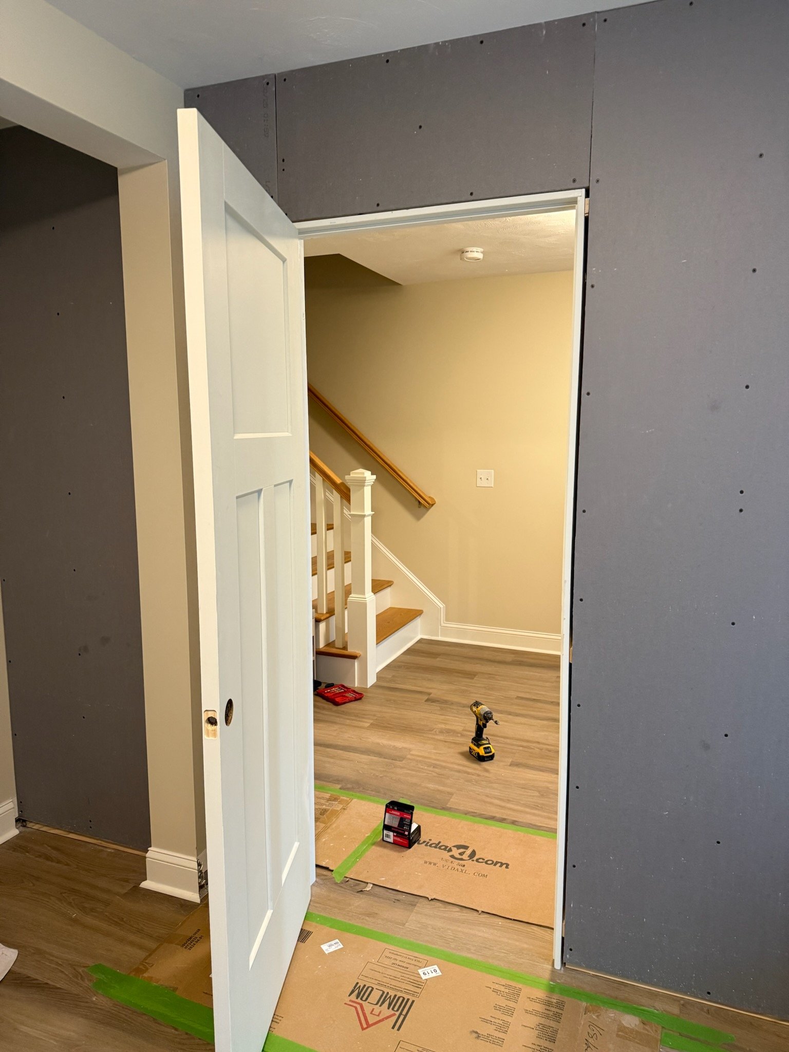 Door installation and wall finishing during Wilmington bedroom conversion