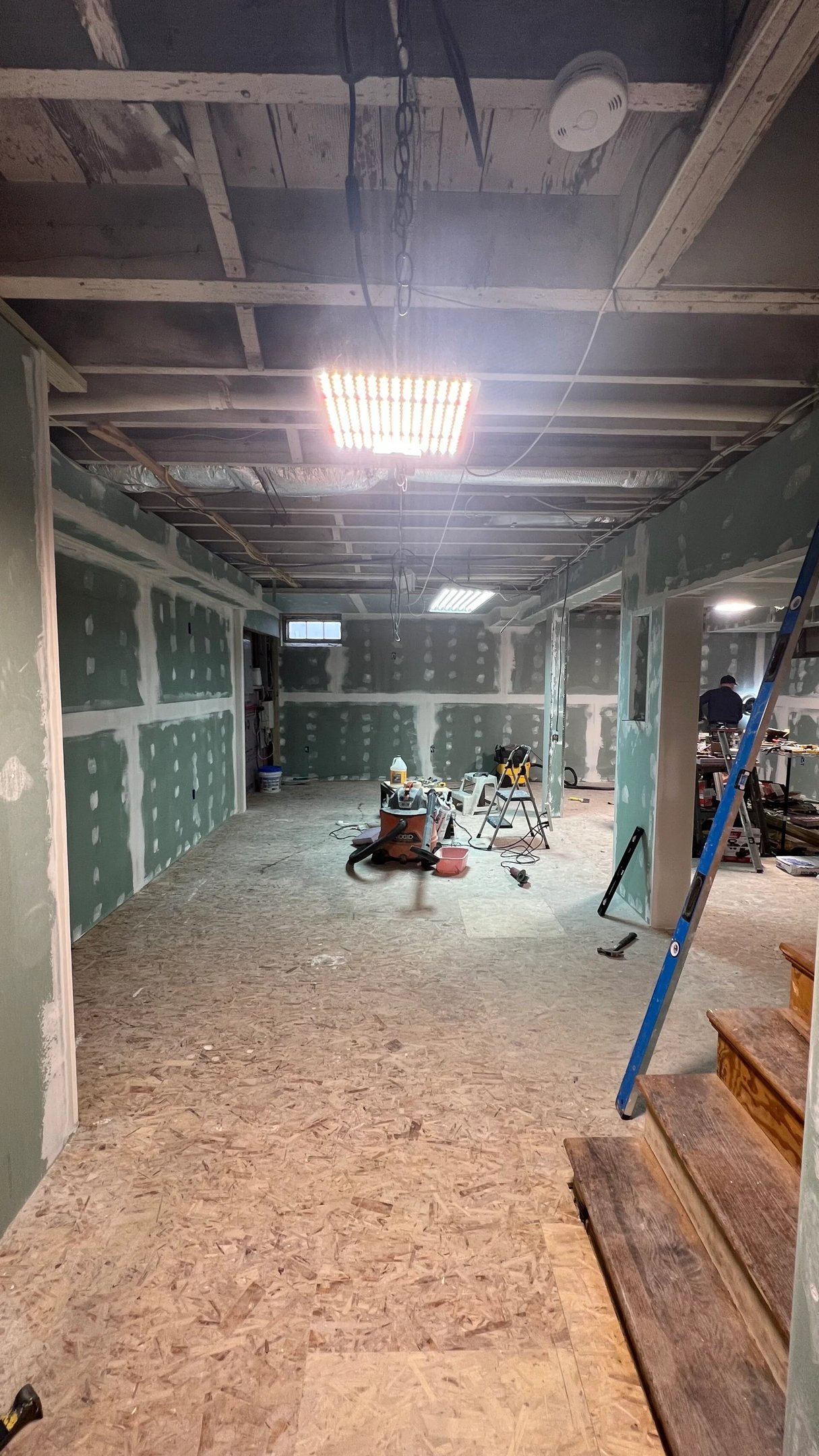 Drywall seams, corners, columns, and wall surfaces being finished during the Marblehead basement renovation