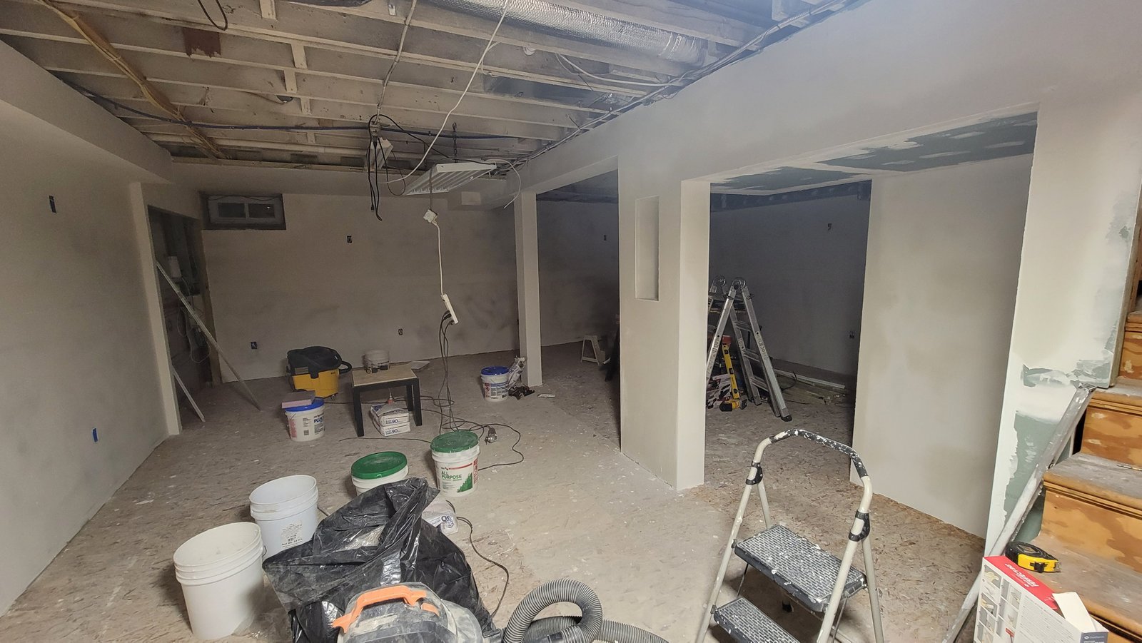Walls and columns being smoothed and prepared for paint during the Marblehead basement renovation
