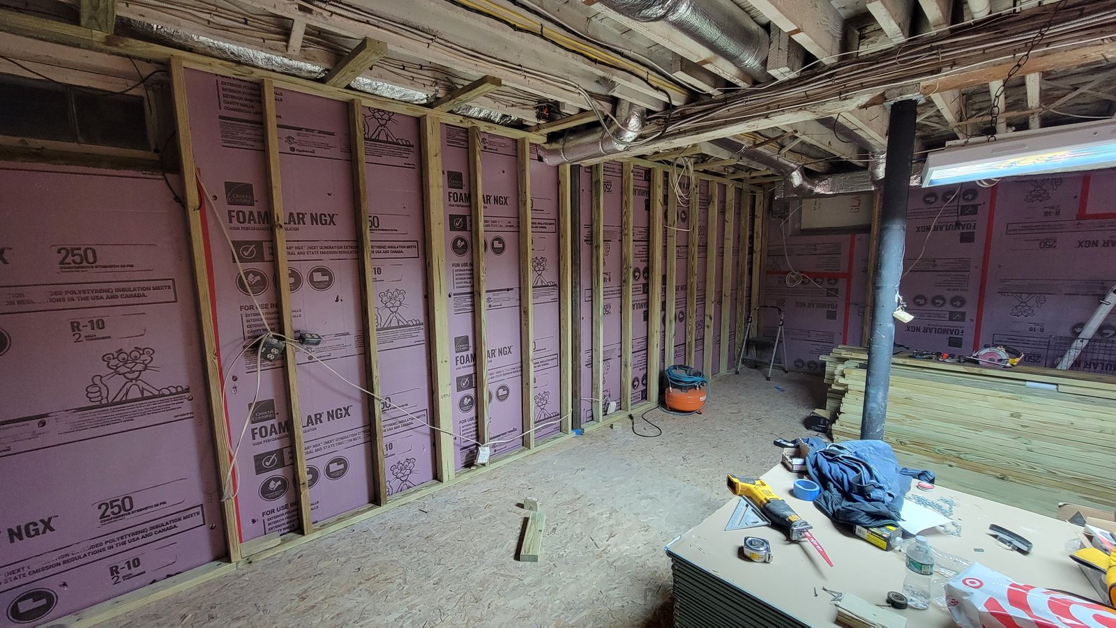 Rigid foam insulation, new wall framing, and the elevated subfloor during a Marblehead basement renovation