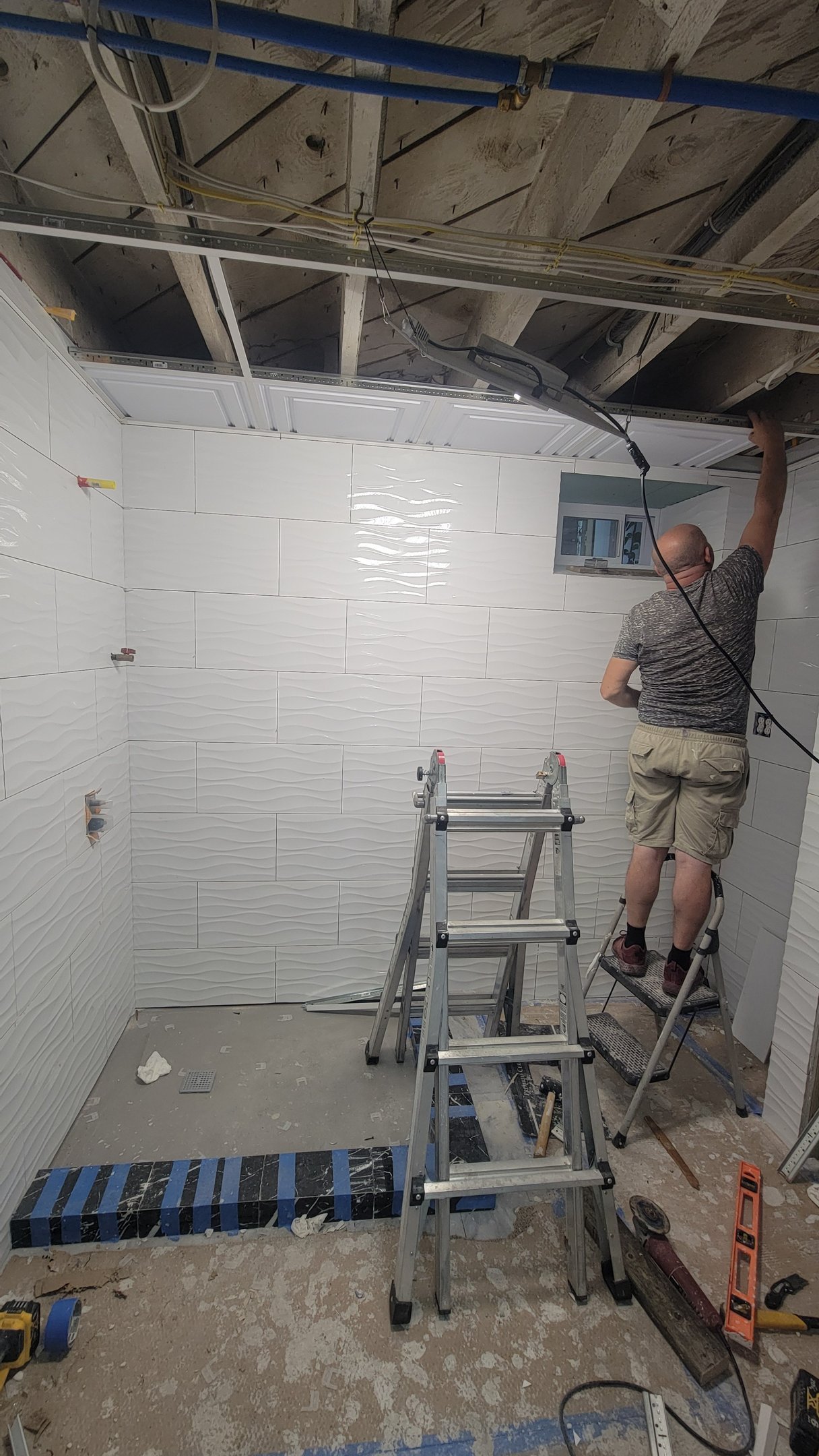 Large-format wall tile installation during a Marblehead bathroom renovation